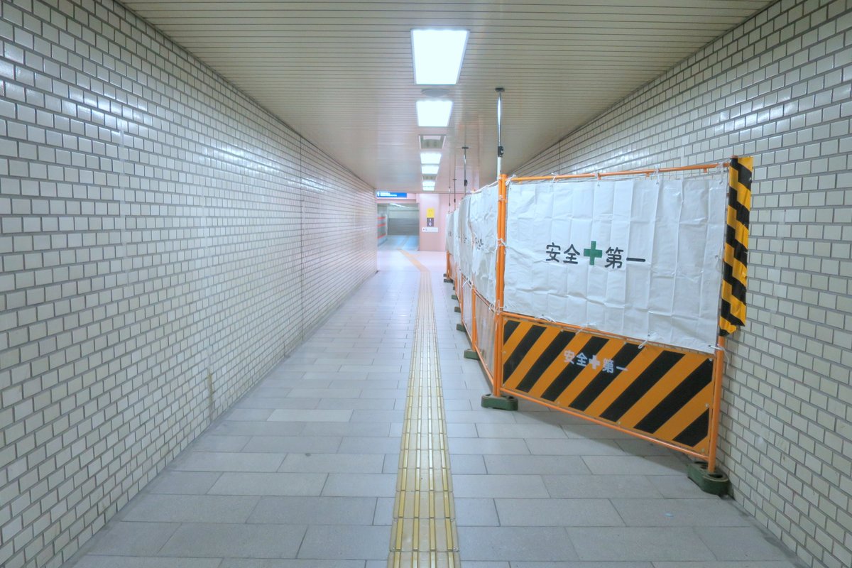 地下通路の工事区画に掲げられた「安全第一」の幕と黄黒の仮囲い