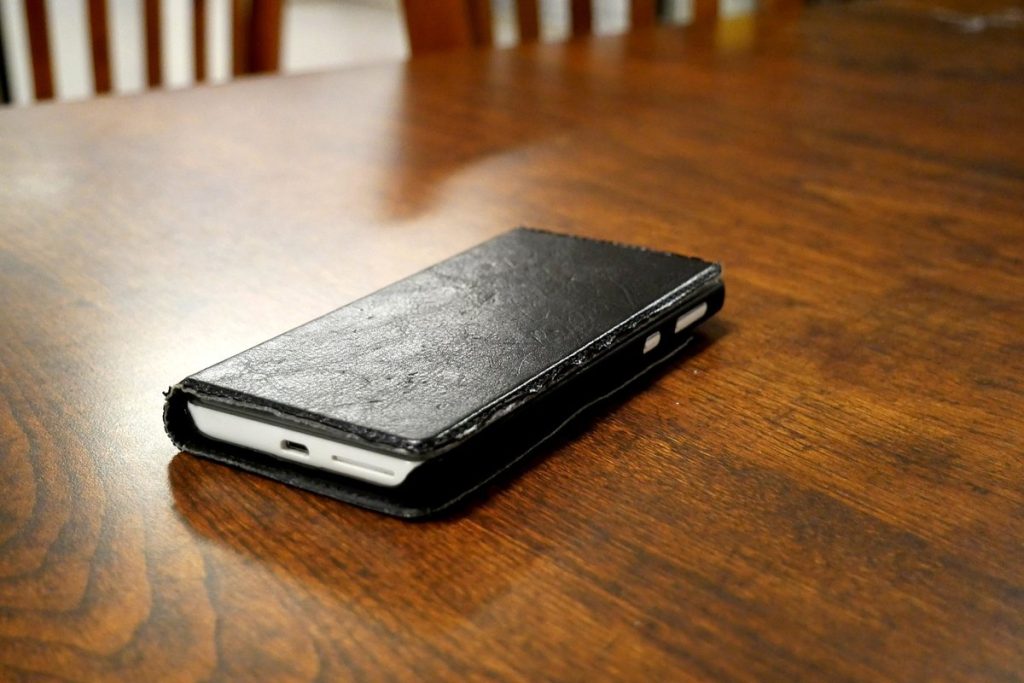 テーブルに置かれた手帳型ケース付きのスマートフォン