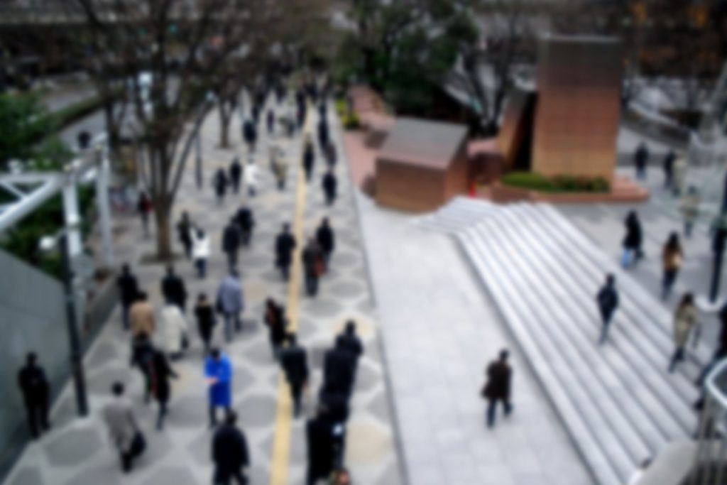 朝の西新宿の高層ビル街を出勤する大勢の人たちを高い位置から見た様子