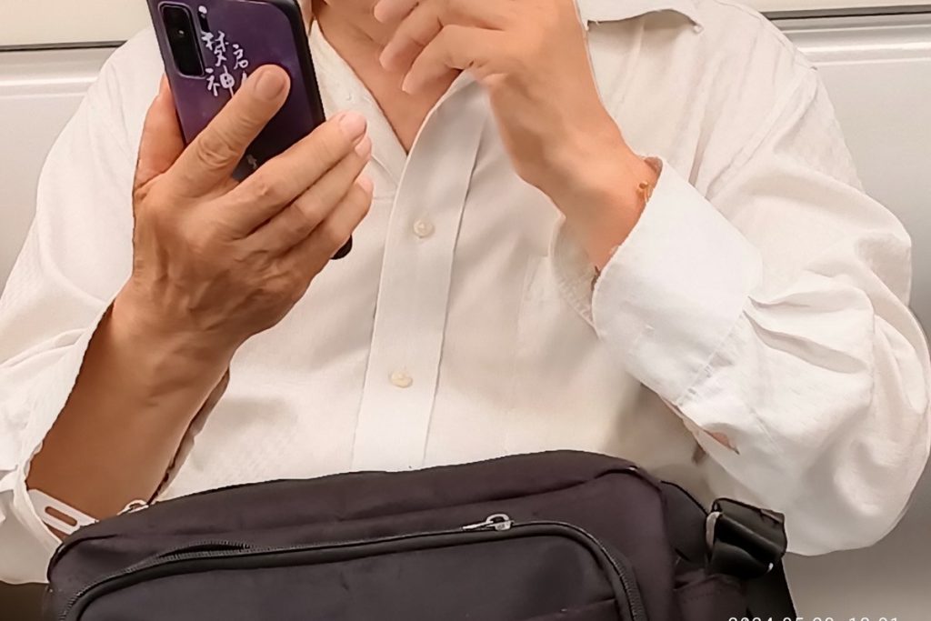 スマートフォンを両手で持つ人