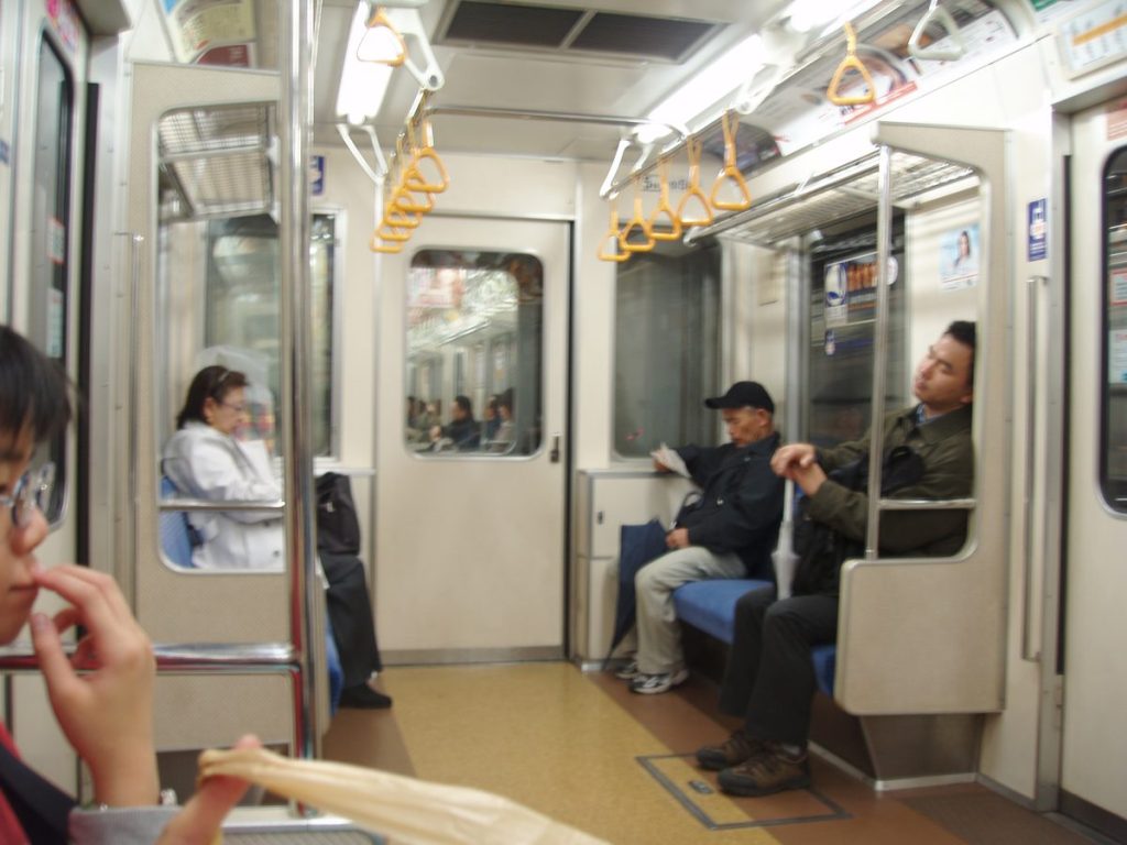 東京の地下鉄車両の車内。座席と通路、つり革が見える様子
