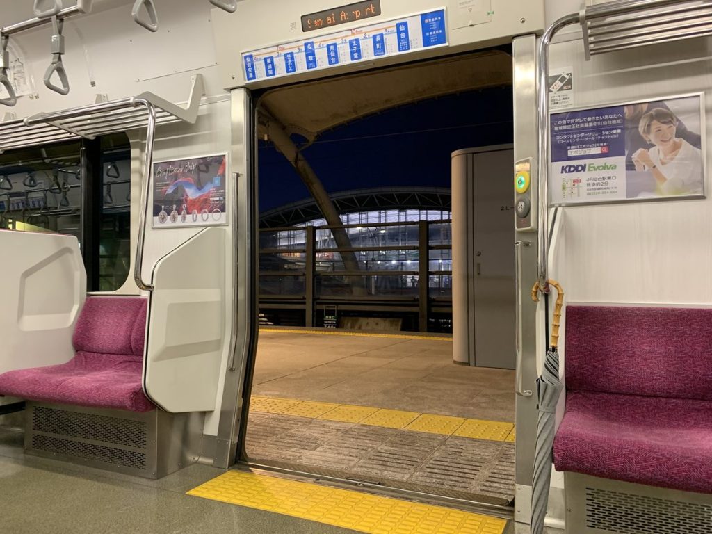 電車の乗降口付近の手すりに、長傘が立てかけられている様子